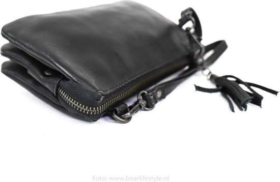 Gedetailleerde kijk op een zwarte leren clutch met franjes en ritssluiting.