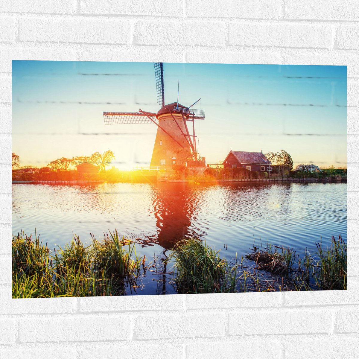 WallClassics - Muursticker - Zonlicht langs Hollandse Molen aan het Water - 80x60 cm Foto op Muursticker