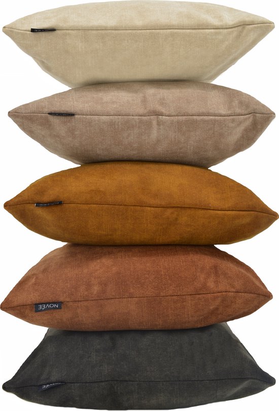 Pile de cinq coussins décoratifs dans différentes teintes terreuses: beige, brun clair, orange, brun rouille et gris foncé.