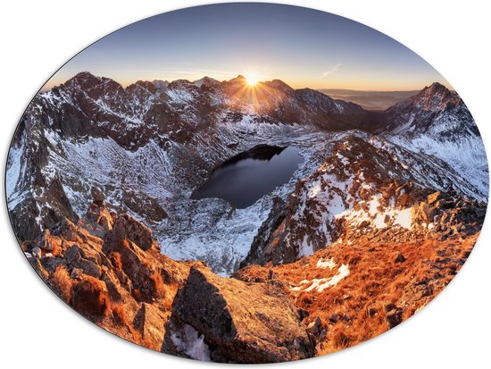 Dibond Ovaal - Zon Zakkend achter Bergen met Sneeuw - 108x81 cm Foto op Ovaal (Met Ophangsysteem)