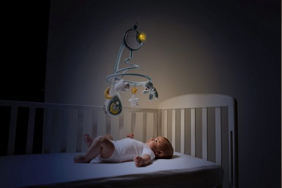 Baby in een wiegje kijkt omhoog naar een blauwe muziekmobiel met een lachende maan.