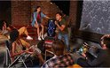 Groupe d'amis chantant avec une enceinte JBL PartyBox lors d'une fête en extérieur