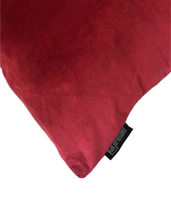 Detail van een donkerrood fluwelen sierkussen met label 'Gek op Kussens!'.