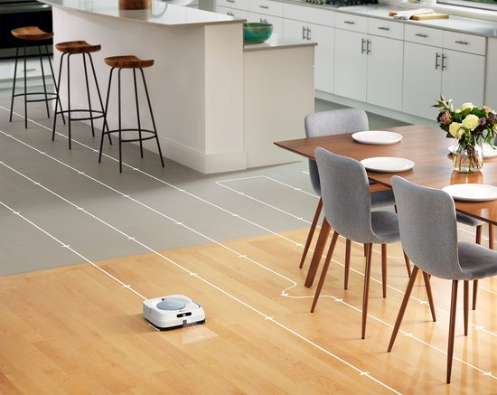Robotdweilrobot op houten en grijze vloeren, volgt een schoonmaakpatroon.