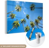 MuchoWow® Glasschilderij 90x60 cm - Schilderij acrylglas - Palmbomen van onderaf tegen een blauwe lucht - Foto op glas - Schilderijen