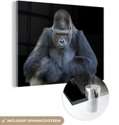 MuchoWow® Glasschilderij 120x90 cm - Schilderij acrylglas - Een Gorilla kijkt indrukwekkend in de camera - Foto op glas - Schilderijen