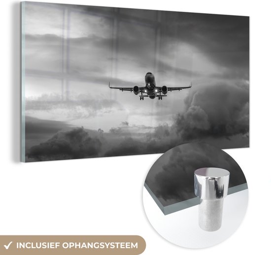 MuchoWow® Glasschilderij 120x60 cm - Schilderij acrylglas - Vliegtuig in een donkere lucht - zwart wit - Foto op glas - Schilderijen