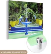 MuchoWow® Glasschilderij 20x20 cm - Schilderij acrylglas - Blauwe fontein en gele bloempotten in de Majorelletuin in Marokko - Foto op glas - Schilderijen