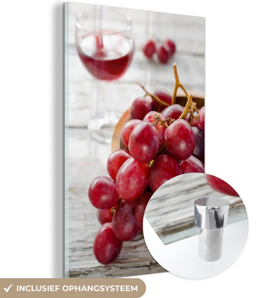 MuchoWow® Glasschilderij 80x120 cm - Schilderij acrylglas - Tros rode druiven in kommetje naast een glas rode wijn - Foto op glas - Schilderijen