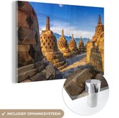 MuchoWow® Glasschilderij 150x100 cm - Schilderij acrylglas - Geel gekleurde Stoepas door de zon bij de Borobudur - Foto op glas - Schilderijen