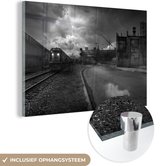 MuchoWow® Glasschilderij 90x60 cm - Schilderij acrylglas - Verlaten gebouwen naast een treinrails - zwart wit - Foto op glas - Schilderijen