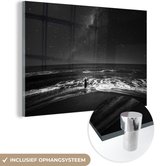 MuchoWow® Glasschilderij 120x80 cm - Schilderij acrylglas - Sterrenhemel boven een vrouw in de zee - zwart wit - Foto op glas - Schilderijen