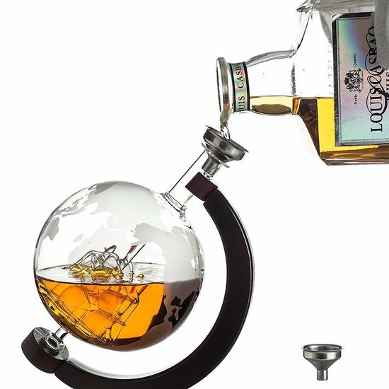 Amberkleurige drank wordt geschonken in glazen wereldbol karaf met schip, met trechter ernaast.