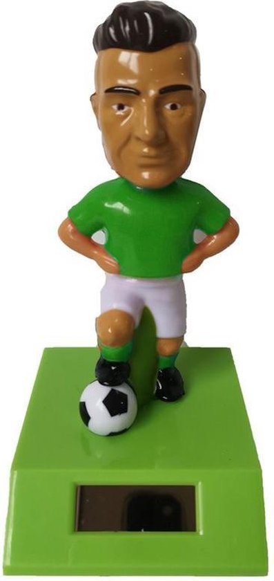 Solar voetballer voetbal speler in groen shirt beweegt bij zonlicht en kunstlicht.