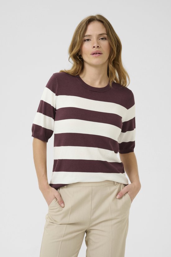 Model met bordeauxrode en witte gestreepte trui met korte mouwen en beige broek.