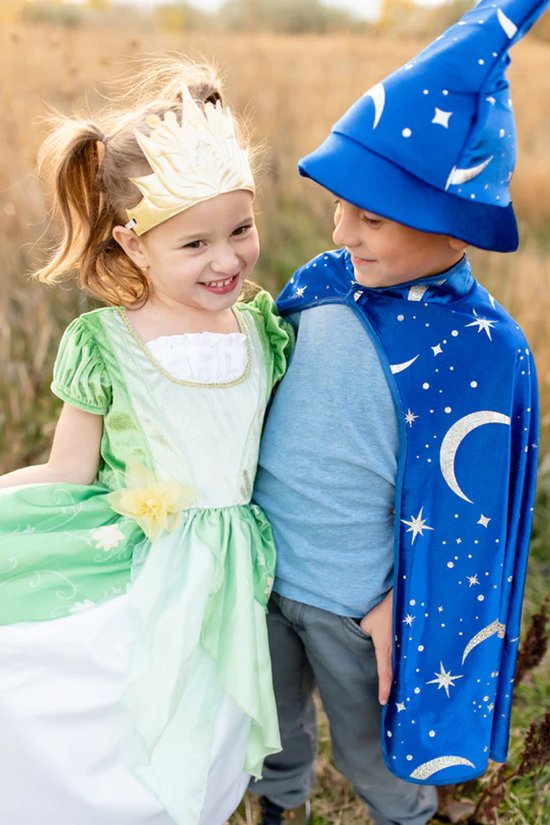 Een lachend meisje in een groene prinsessenjurk en een jongen met een blauwe tovenaarsmantel en hoed vol sterren en manen.