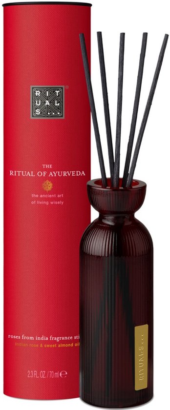 Rode kartonnen verpakking voor 'The Ritual of Ayurveda' geurstokjes, naast een gevulde donkere glazen diffuser.