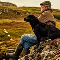 Man met hond en groene Muck Boot Muckmaster laarzen in heidegebied.