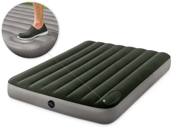 Donkergroen luchtbed met grijze rand en verticale ribbels. Voet wordt getoond die op het matras drukt.
