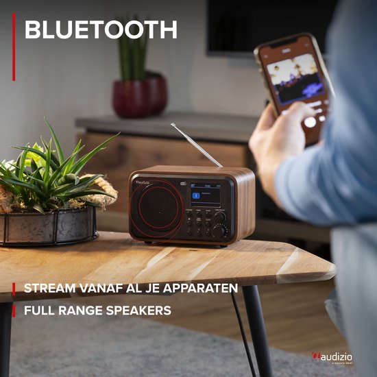 DAB radio met houtlook, met een smartphone die verbindt via Bluetooth.