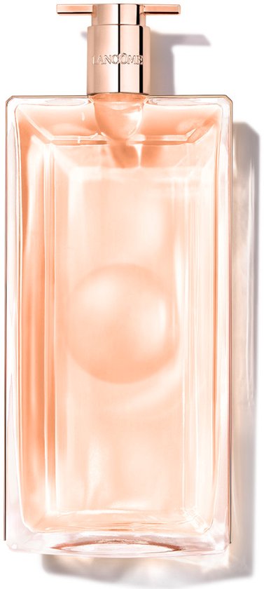 Een rechthoekige glazen parfumfles met een rosegouden dop en vloeistof in een perzikkleurige tint.