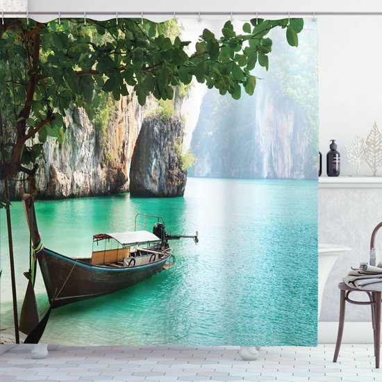 Un bateau longtail en bois dans une eau turquoise près d'une île tropicale avec des falaises abruptes, sous un arbre aux feuilles vertes.