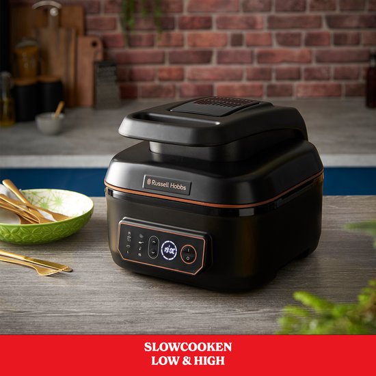 Zwarte Russell Hobbs multicooker op een houten aanrecht, met ingesteld slowcooken op HIGH.