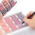 Hand die bijbel tabsticker 'Acts' opplakt, met stickers met titels zoals 'Titus', 'Philemon', 'Hebrews'.