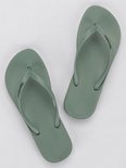 Lichtgroene Ipanema teenslippers met golvend patroon op de zool en merknaam.