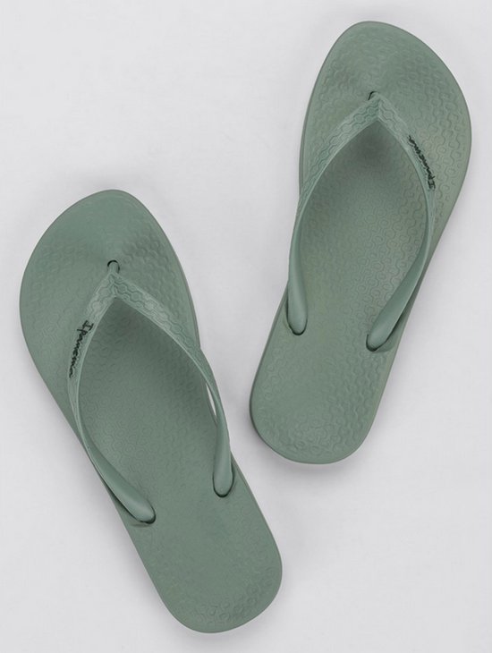 Lichtgroene Ipanema teenslippers met golvend patroon op de zool en merknaam.
