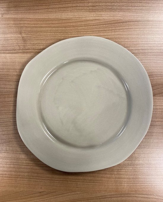 Een lichtgrijze, onregelmatig gevormde dinerbord van vtwonen.