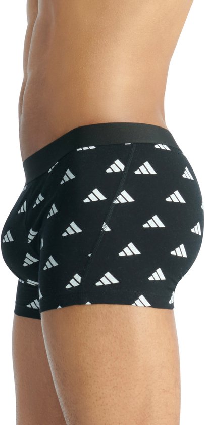 Zijaanzicht van een man met een zwarte Adidas boxershort met witte logo's.