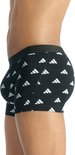 Zijaanzicht van een man met een zwarte Adidas boxershort met witte logo's.