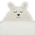 Sluit aan op een beige baby wikkeldeken met konijnenoren en een geborduurd gezichtje.