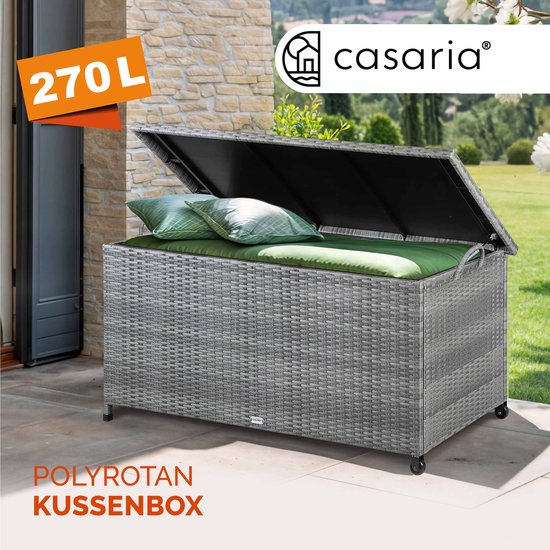 Grijze polyrotan kussenbox van 270L van Casaria, gevuld met kussens, op een terras.