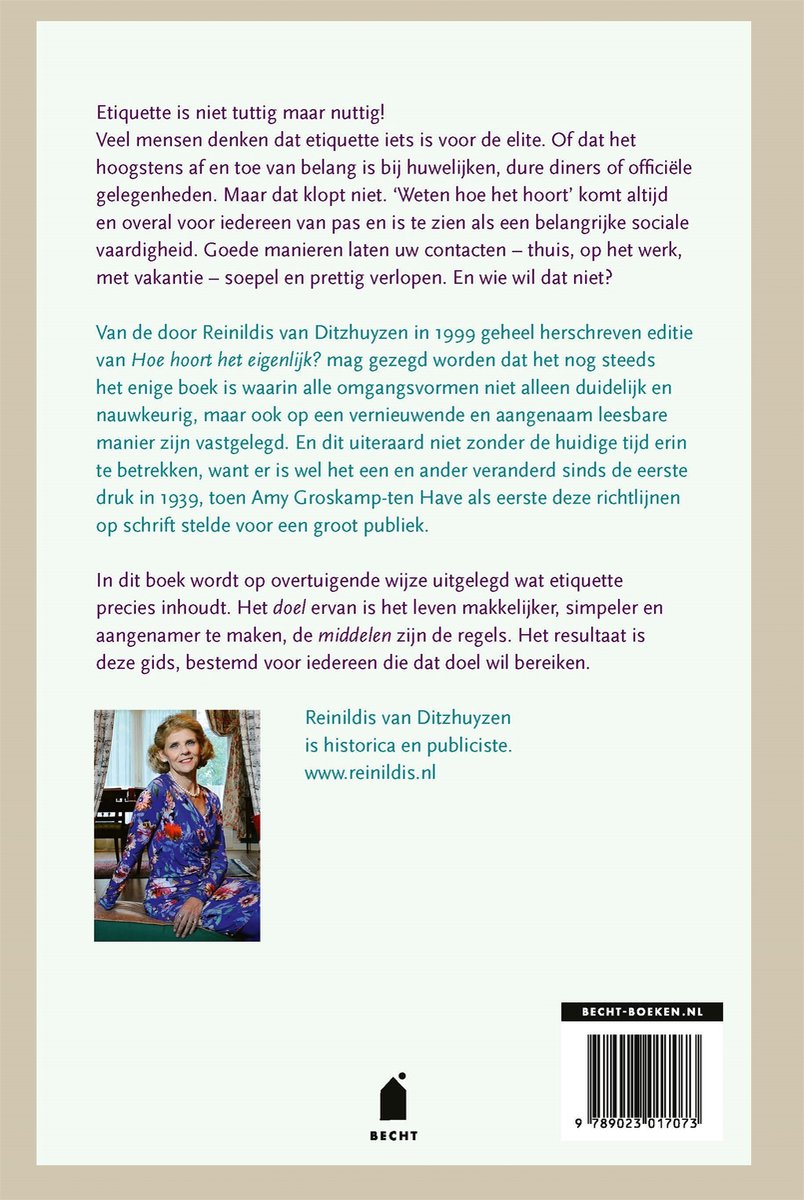 Vrouw in blauw jasje met bloemenprint en parelketting, lachend.