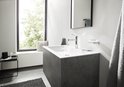 Slanke, glanzende chroom wastafelkraan met platte hendel in een moderne badkamer.