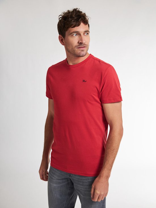 Man met rood t-shirt met korte mouwen en een ronde hals, die aan de kraag trekt.