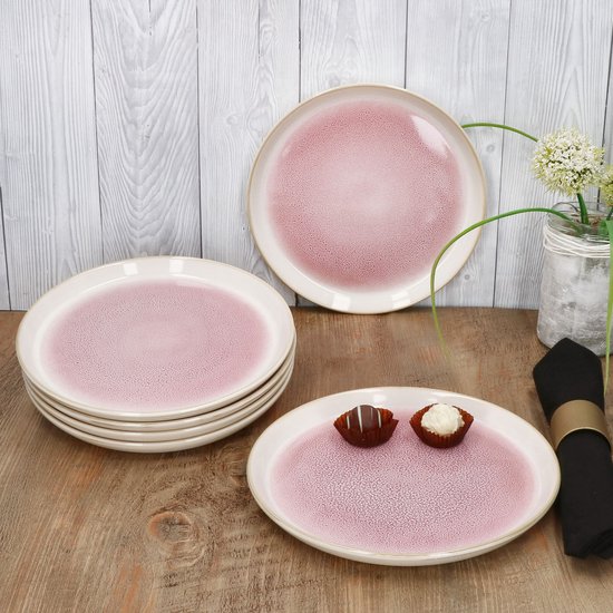 Twee roze borden met crèmekleurige rand en gespikkelde textuur op een houten tafel. Eén bord bevat twee bonbons.
