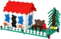 Plus-Plus huisje met rood dak, witte muren, blauwe ramen, hekje en een boom. Voor het huisje staat een bankje.