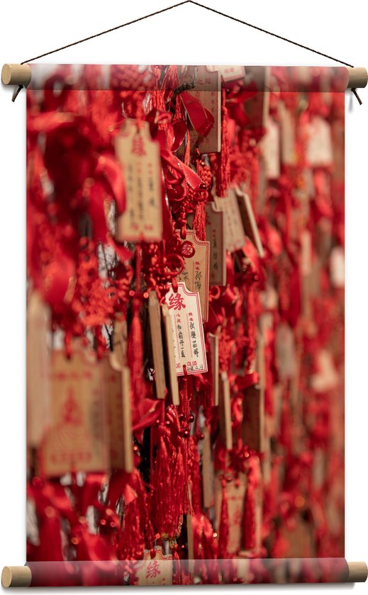 Textielposter - Rode Sleutelhangers met Chinese Tekens aan een Muur - 40x60 cm Foto op Textiel
