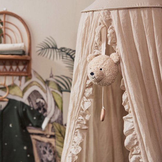 Muziekhanger teddybeer hangt in een crèmekleurige hemel met ruches.