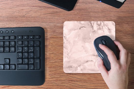 Roze marmeren muismat op een houten bureau, met een hand die een muis bedient.