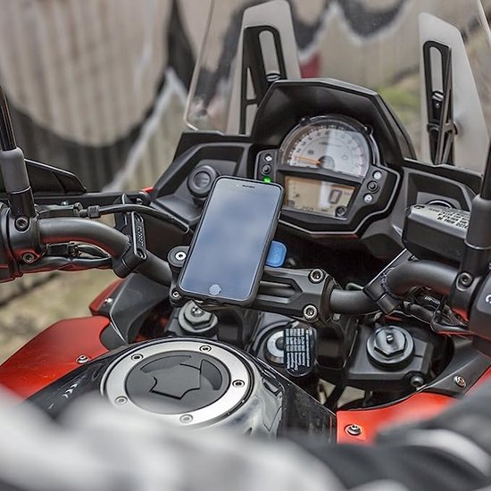 Quad Lock stuurbevestiging met telefoon op het stuur van een motor.