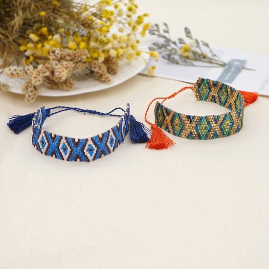 Twee handgeweven armbanden met kralen en kwastjes. Eén met blauwe, witte en bruine ruitjes, de ander met groene, blauwe en gouden ruitjes.