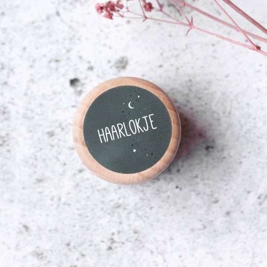 Houten doosje met donkergroene sticker op de deksel met 'HAARLOKJE' en sterren.