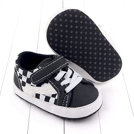 Zwarte babysneakers, detail van de witte zolen met antislipnoppen.
