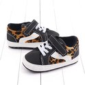 Zwarte babysneakers met klittenbandsluiting, luipaardprint accenten en witte veters.