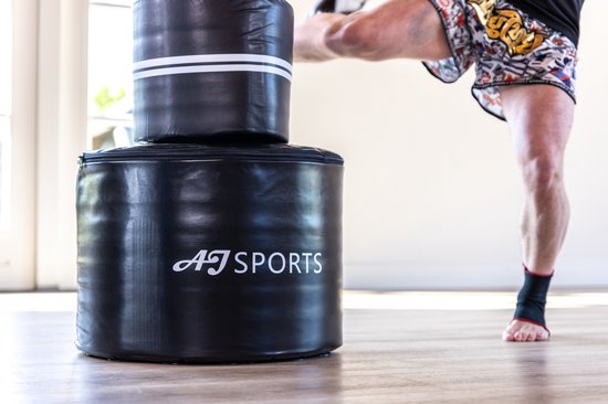 Graserige foto van de stevige, zwarte voet van de AJ-Sports bokspaal.