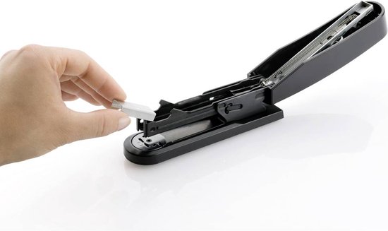 Hand op zilveren nietenhouder, zwarte nietmachine open.